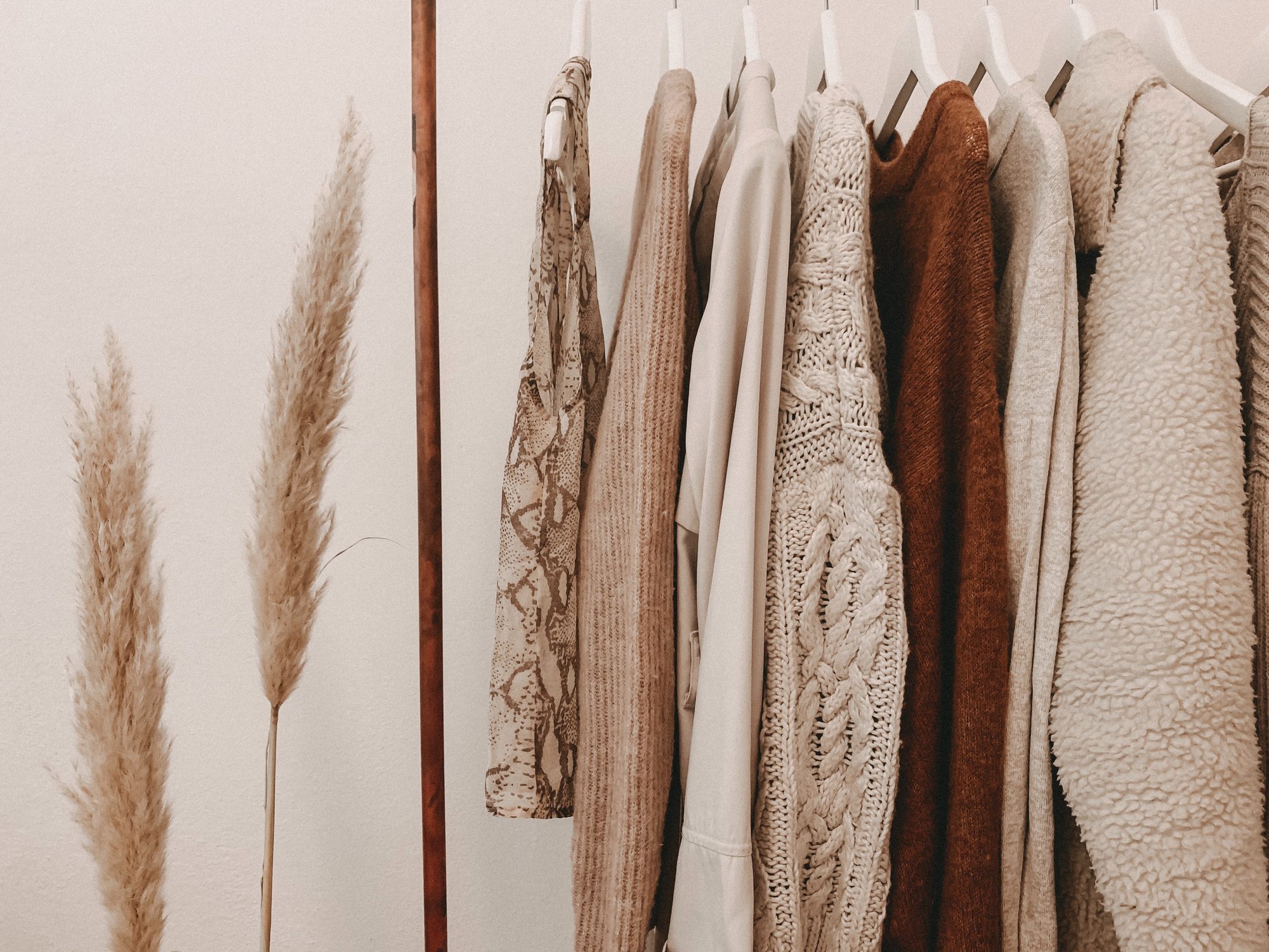 Rail of neutral-toned knit sweaters
